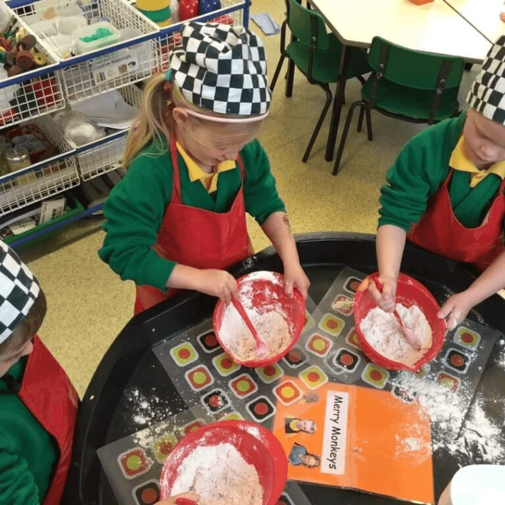Schoolchildren whisking bowls of flour